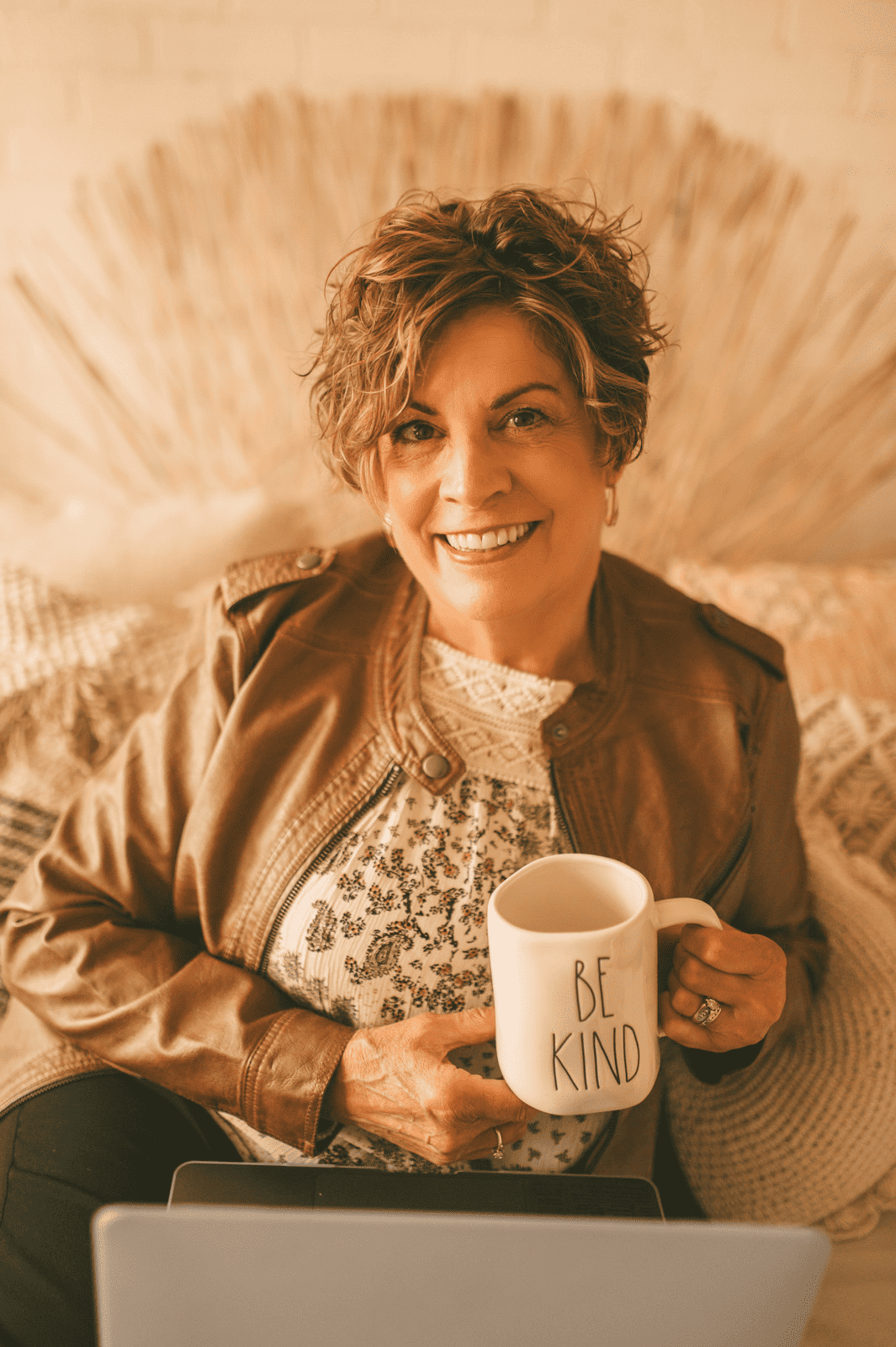 Dr. Liz Jenkins sitting with coffee mug and laptop
